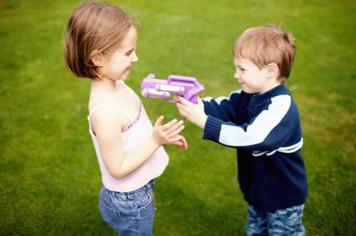 Мальчик играет в куклы, баюкая ее, укладывая спать и обнимая