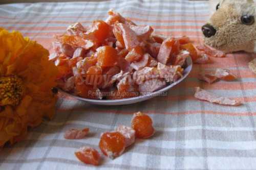 Вымоченные и очищенные от кожицы апельсиновые корочки нужно нарезать тонкими полосками, залить свежей водой и прокипятить в течение минут, а после дать хорошенько стечь, переложить в кастрюлю, засыпать сахаром и поставить на медленный огонь, периодически помешивая